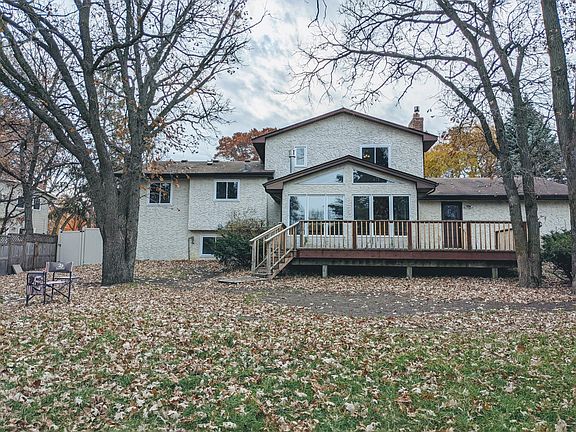 Back of the home with large wrap around deck and firepit area