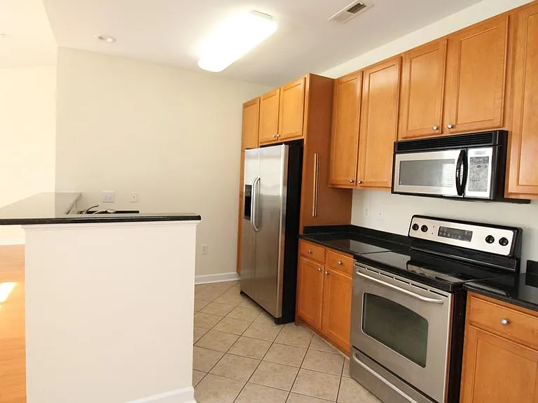 Alternate view of kitchen with breakfast bar and large side/side refrigerator