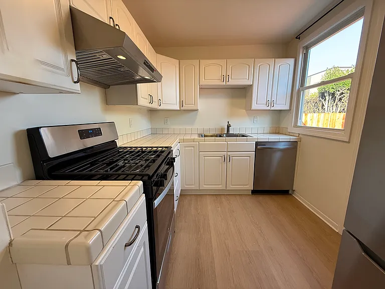 Efficient kitchen is equipped with stainless steel appliances featuring a patio door that opens to a private side yard and backyard.