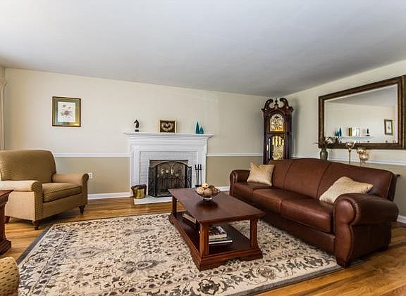 Sunny living room has a brick fireplace