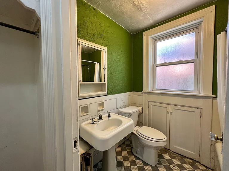 This botanical green bathroom feels like an extension of the greenery surrounding the property. Featuring plenty of built in storage, a medicine cabinet, and the original sink.