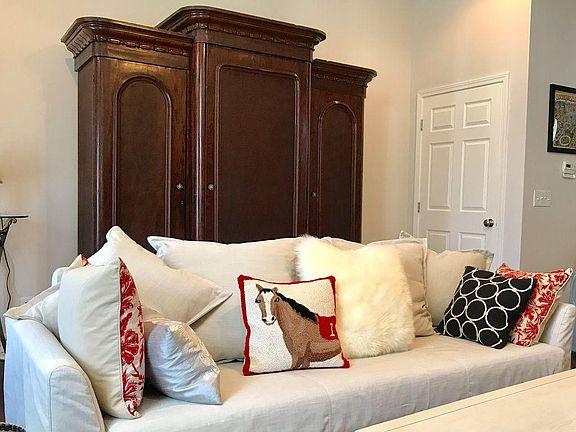 Living room area with storage armoire and queen sized sleeper sofa