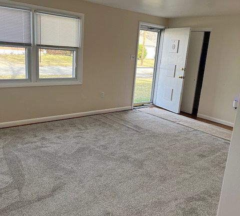 Living room looking towards the front door. Double wide coat closet behind the front door. Brand new carpet.