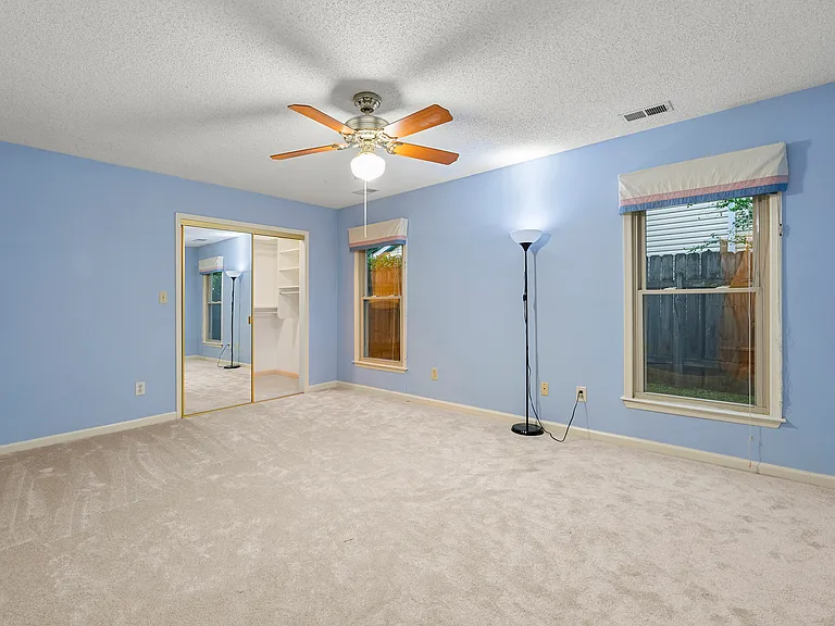 Master bedroom downstairs. View towards the backyard. Mirrored walk in closet doors