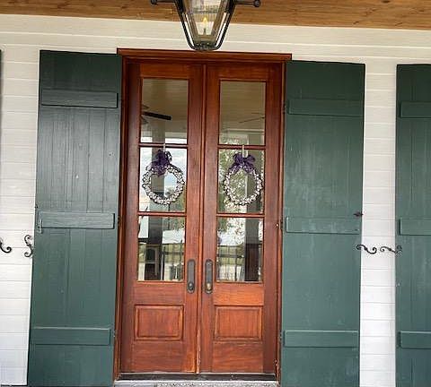 Copper gas lantern and one of three sets of mahogany French doors with operable French Quarter Green shutters.