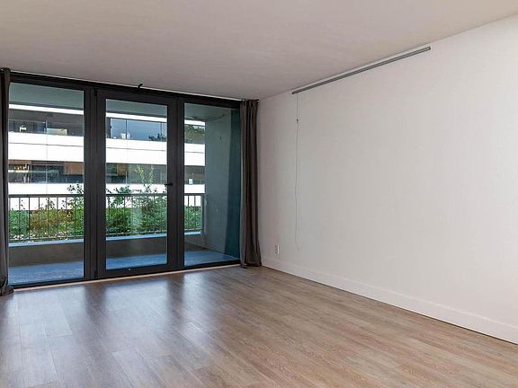 Looking out windows of front room. Lovely sense of space, visually connecting the inside to the outside via the balcony and landscaping