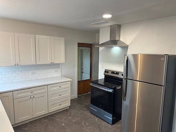 Kitchen showing new stove/oven and refrigerator.