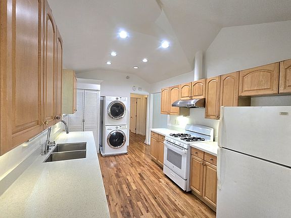 Galley kitchen with stacked in-unit washer/dryer. Ample cabinet space for every cooking need.