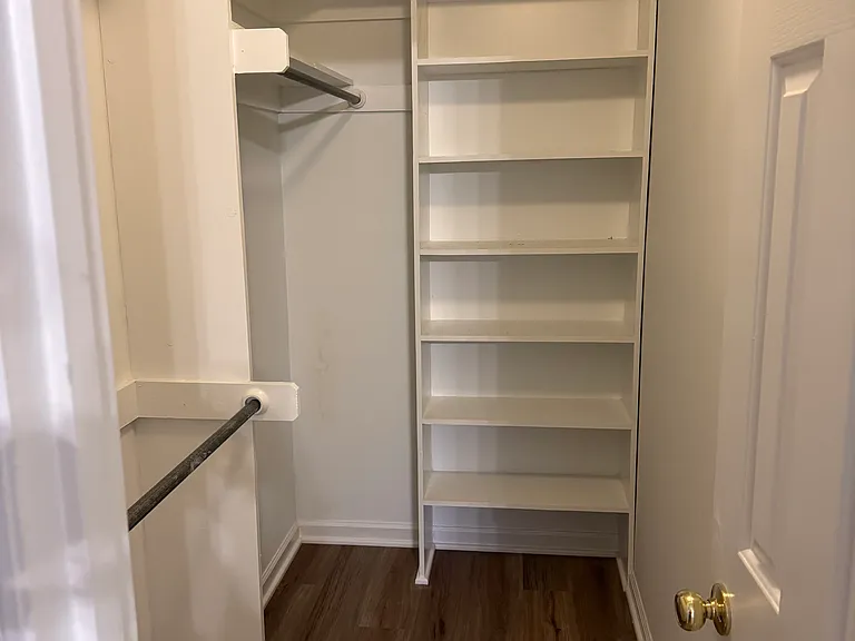 Master bedroom walk-in closet with built in shelves, full length and coat hanging areas.