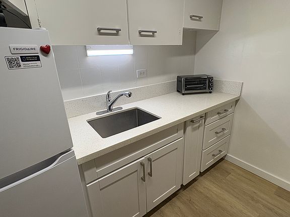 Kitchen area, includes table setting for (4) persons (plates, glasses, silverware, cutlery), toaster oven and 2 burner hotplate