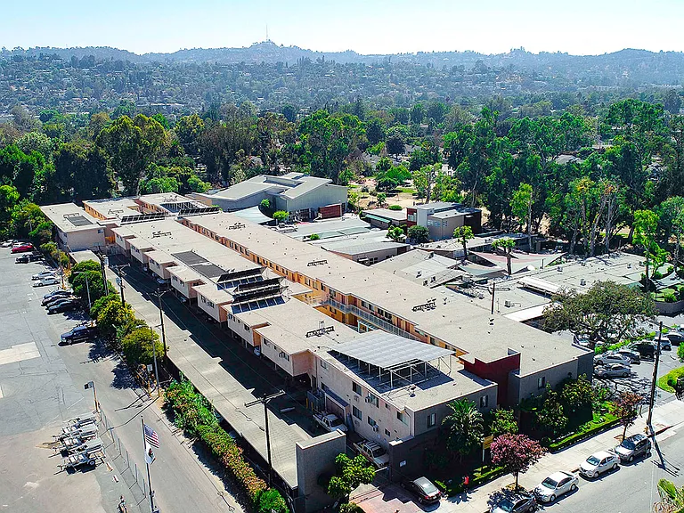 Aerial drone photo of Woodbridge Park Apartments, showing white solar roofs and Solar Panels.