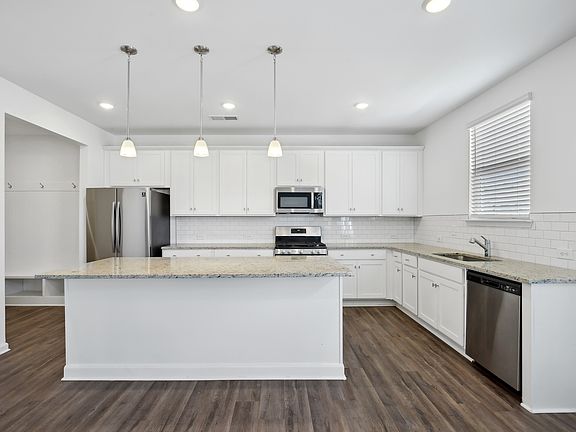 Hickory C Layout - Open Kitchen with lots of counter space, island with breakfast bar seating, subway tile backsplash and stainless steel appliances