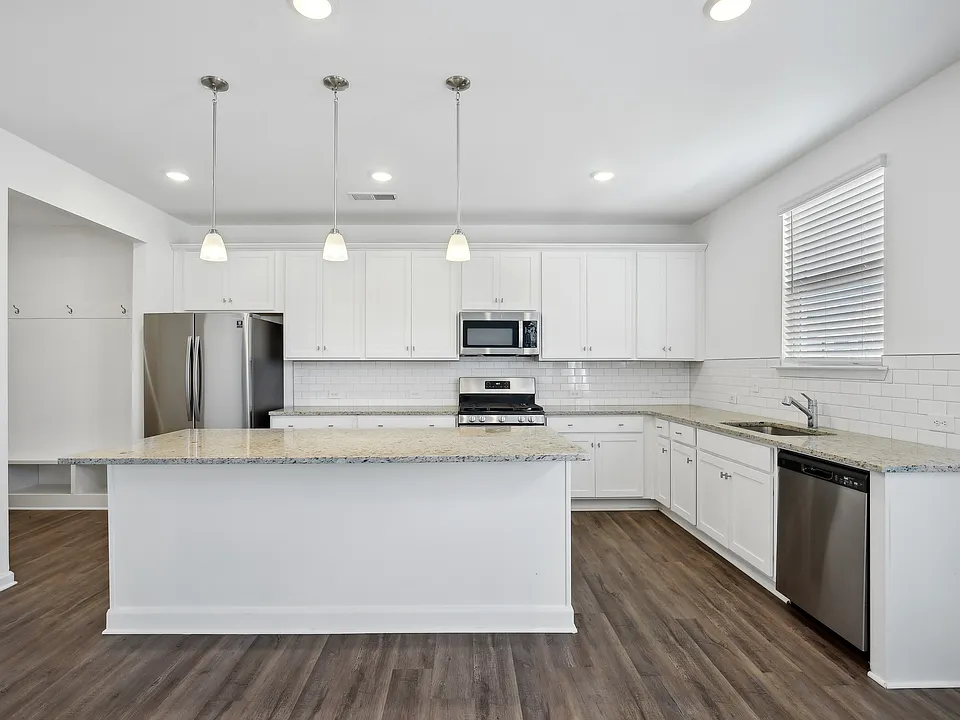 Hickory C Layout - Open Kitchen with lots of counter space, island with breakfast bar seating, subway tile backsplash and stainless steel appliances
