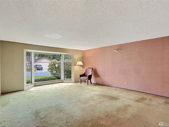 Large bay window in living area allows natural light to flow through.