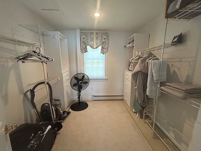 Large walk-in closet in primary bedroom with built-in storage.