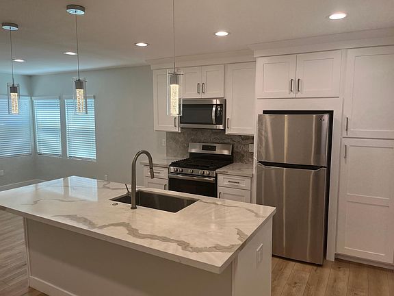 White shaker cabinets with soft-close drawers and stainless-steel appliances