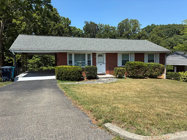 Bright front exterior with driveway parking, covered entry, and mature landscaping.