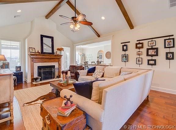 Vaulted living room ceiling with solid wood floors! Wood beams added by seller. Gas fire place.