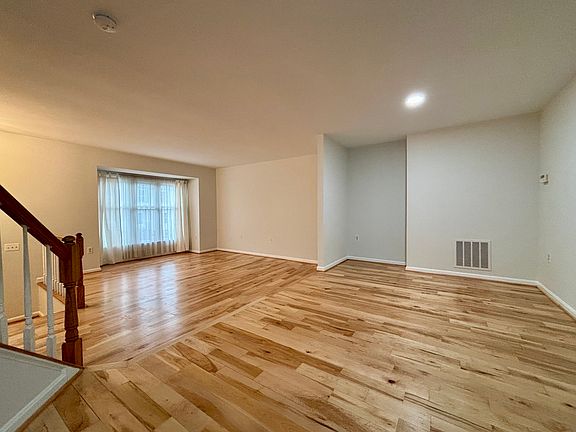 Step into a welcoming entryway that opens seamlessly into the living room, dining area, and powder room. This level features gleaming hardwood floors and freshly painted walls, creating a bright and elegant atmosphere perfect for everyday living.