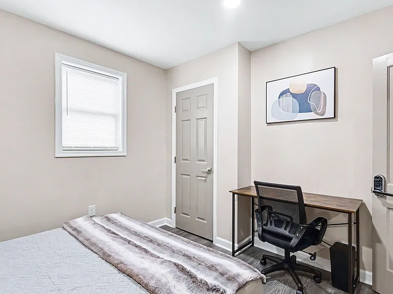 Private bedroom with a window, neutral finishes, and a dedicated desk areaideal for sleep, study, and work-from-home.