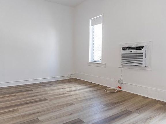 Spacious bedroom with windows overlooking tree-lined downtown Miami Shores