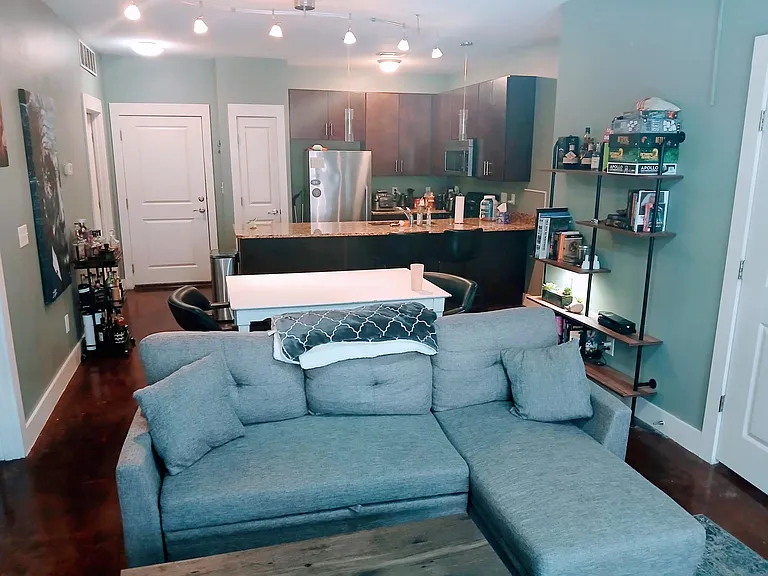 Living room view looking towards kitchen and front door. Multiple options for living room set up