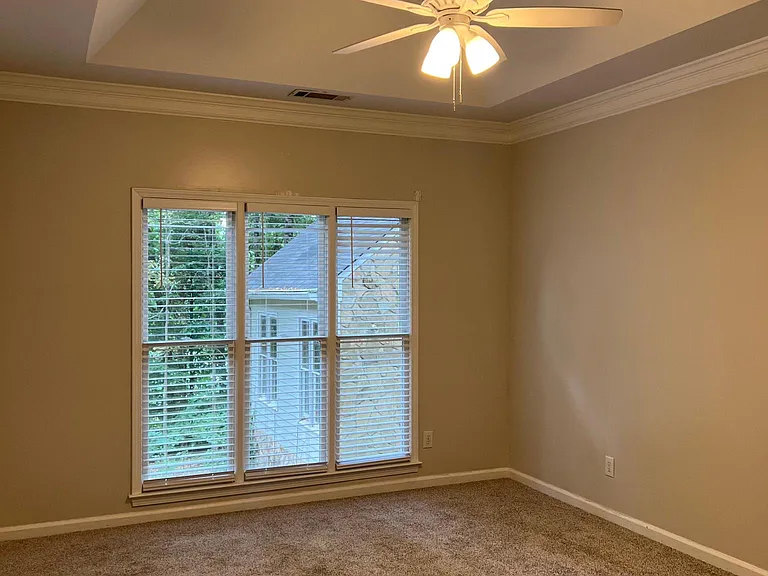 Master bedroom on main with ceiling fan set in trey ceiling