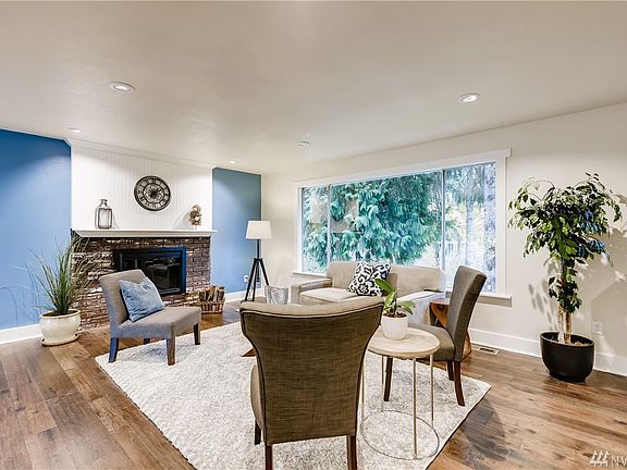 Living room with new hardwood floors, wood burning fireplace, open layout to kitchen and dining room.  New paint throughout.