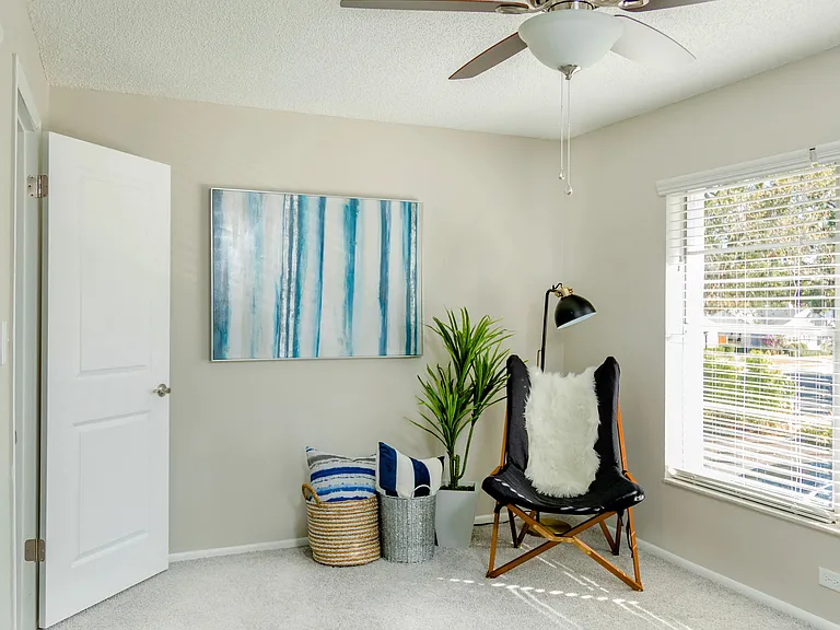 Revel in the warmth of a sun-drenched bedroom with plush carpeting, a roomy walk-in closet, and a modern ceiling fan for ultimate comfort a space inviting you to unwind and recharge.