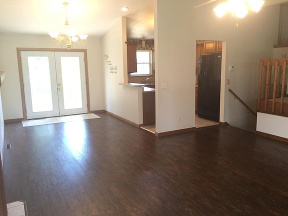 Fireplace corner on left, french doors to 2 tier patio deck straight ahead, Kitchen in right top corner. Stairs that lead down go to2nd Master bedroom and attached bath, laundry room and garage.
