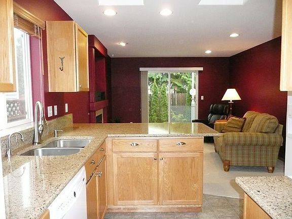Looking from Kitchen to cozy family room and access to fenced backyard.  Natural gas fireplace has blower and remote control.