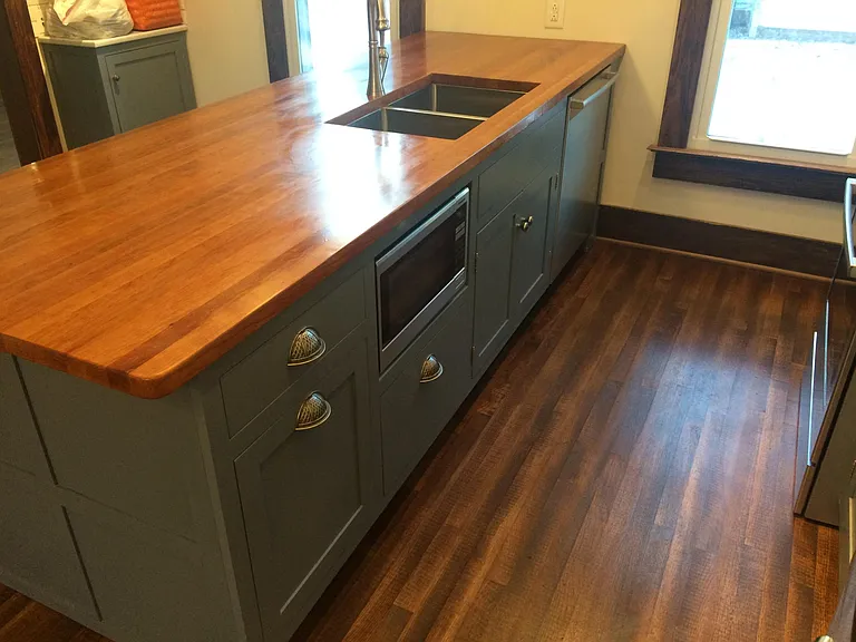 microwave, dishwasher and sink are in the island, to the left of the microwave is a pull out trash