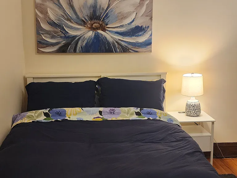 Second Bedroom with new full-sized Purple mattress bed, desk, chair, cabinet, rolling cart, nightstand, two lamps, an accent chair, rug, artwork and large closet.