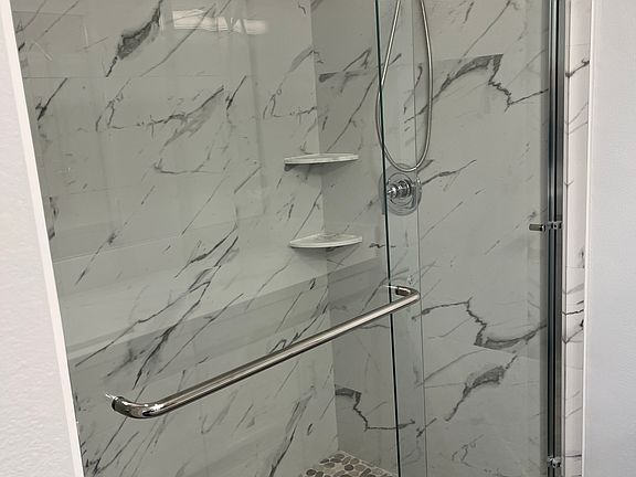 Brand new tiled shower with pebble floor.