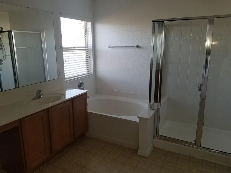 Master bath has two sinks, bathtub, and shower area.