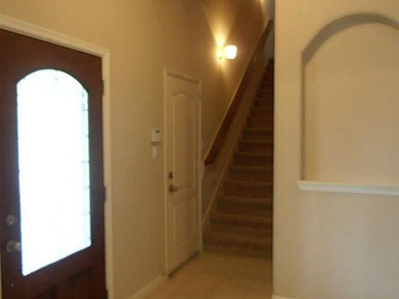 foyer with art niche and stairs to bonus room up