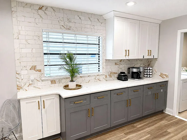 Expansive counter space with ample cabinetry, tile backsplash, and a window over the work area for natural light.