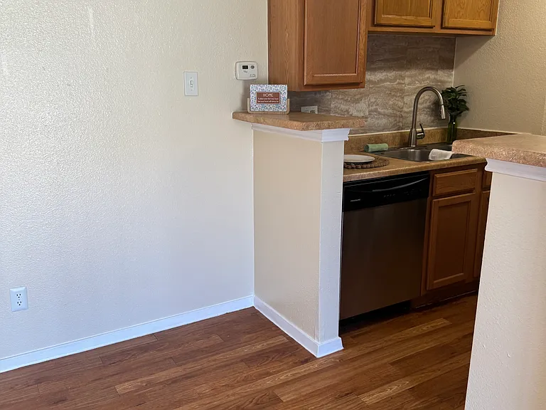 A petite dining area near the kitchen, featuring exquisite faux-wood flooring and original cabinetry.