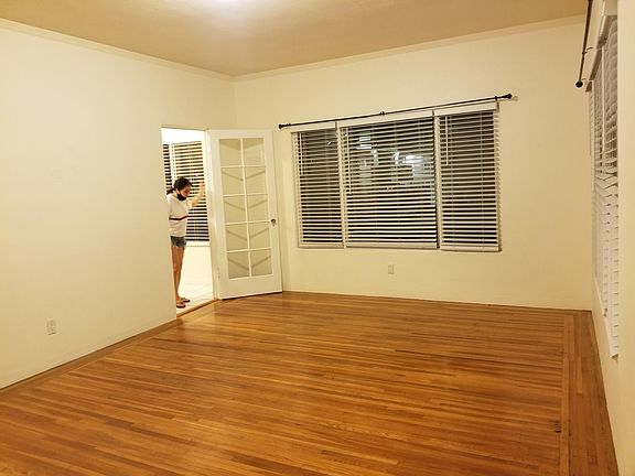 Main room with east facing windows (facing Spruce St.), person standing inside one of the doors to kitchen