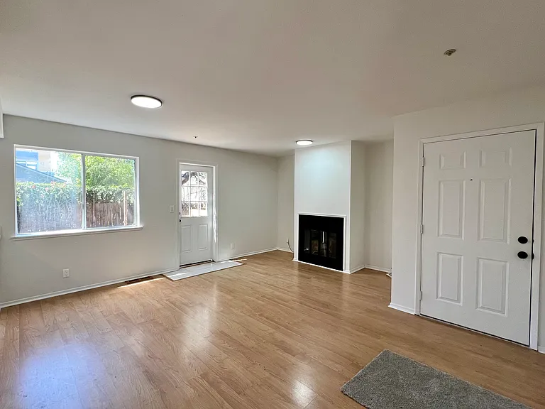 Front door entrance opens into living room. Window door leads out to backyard.