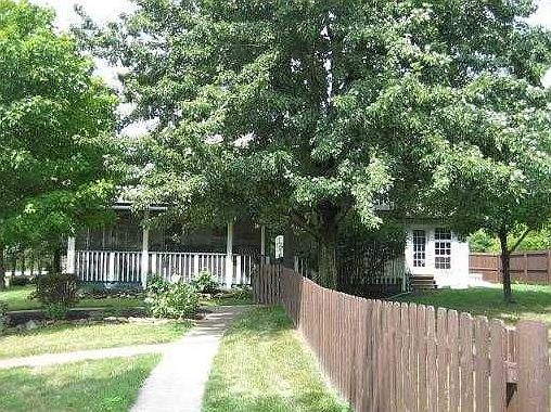 Rear of home showing perrenial gardens, wrap around screened porch