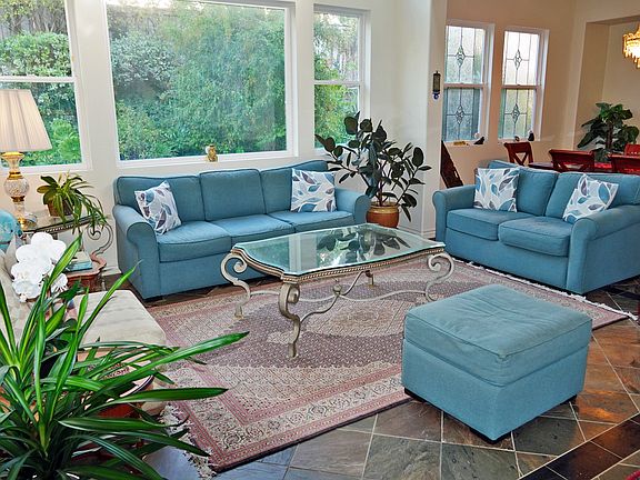 Living room--large windows, some with lead glass artistry; it has high ceilings and is bright and open.