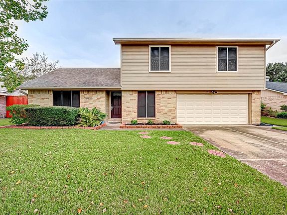 The front yard is meticulous with lush green grass and mature shrubs.