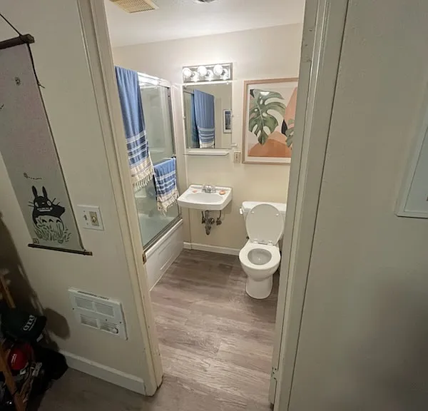 Well lit bathroom with glass shower doors and spacious linen closet inside.