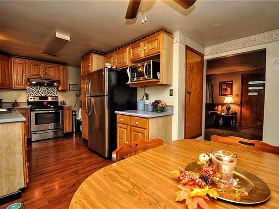 The warm and bright eat-in kitchen has beautiful woodwork from the cabinets to the laminate hardwoods.
