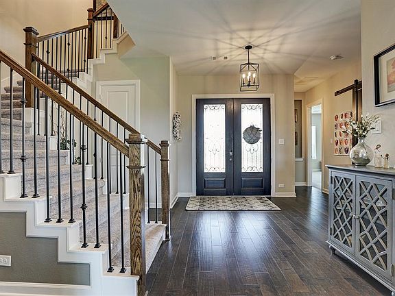 Exquisite entry with double front doors, gleaming hardwoods, and elegant staircase.