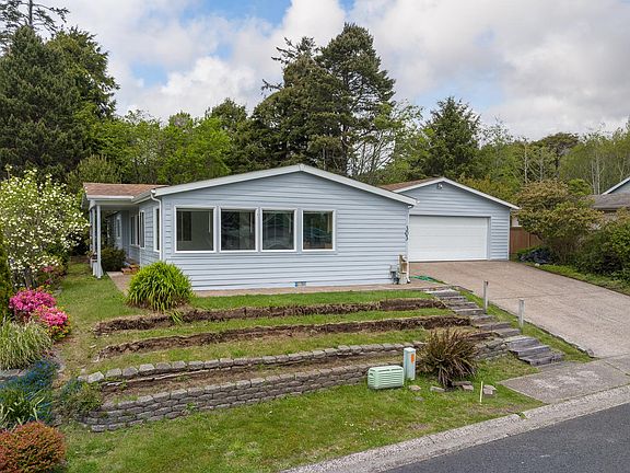 FRONT OF HOME ., DRIVEWAY AND LARGE GARAGE W L SIDE BEING ENTRY DOOR @ 303 NE 70TH ST