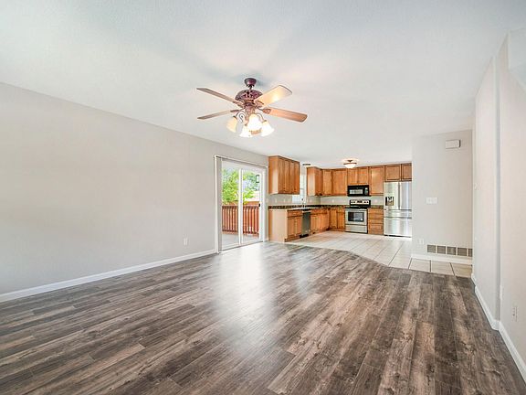 View across main living area & eat in kitchen. Access to side patio through sliding glass doors.