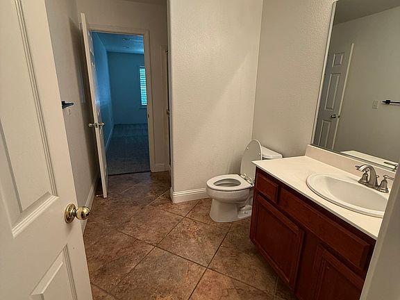 Downstairs guest bathroom from hallway looking into downstairs bedroom