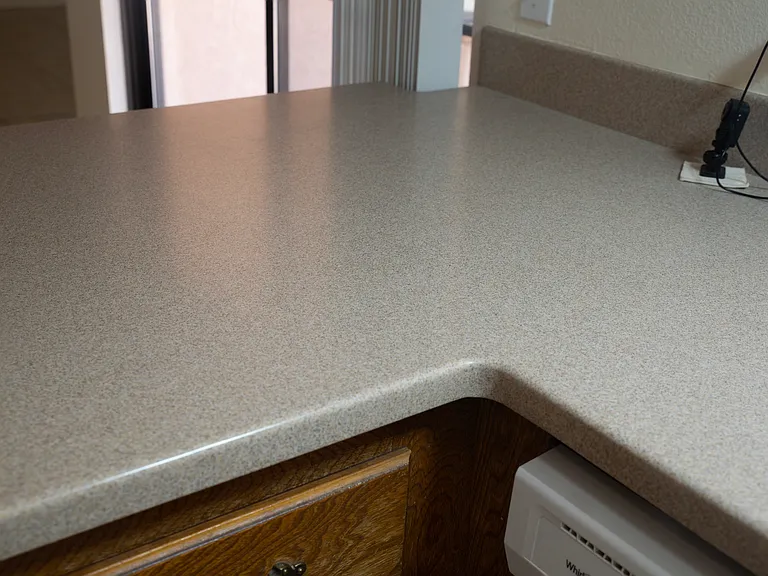 Beautiful neutral Corian counters with back splash.